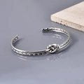 Nahaufnahme der gedrehten silbernen Edelstahl-Knoten-Manschette mit strukturierter Optik - Silber