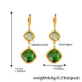 Detailed view of geometric earrings with green glass stones and gold stainless steel finish - Gold Green Glass