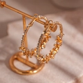 Close-up of golden geometric hoop earrings with sparkling white crystals on a gold stand - Gold Hoop (HE775)