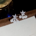 Dettaglio ravvicinato di orecchini a stella in zircone con tre perle bianche su perno argento - Argento