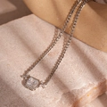 Close-up of silver Cuban chain necklace with an octagonal zircon pendant on stone background - Silver Zirconia Square Necklace
