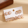 Dettaglio del set di orecchini dorati con strass, perle e fiocchi su espositore - Set di 5 Paia / Oro (Set di 10)