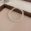 Nahaufnahme eines Perlenarmbands mit glänzenden Süßwasserperlen auf Holzgrundlage - Weiß-6mm