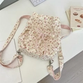Détail d'un sac à dos en toile fleurie avec fermeture à cordon et bretelles à carreaux - Rouge