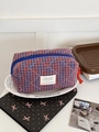 Detail of quilted checkered toiletry bag with red tassel zipper and blue grid pattern - Octagonal Bag (Small) / Red