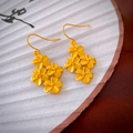Macro detail of matte gold flower drop earrings with a vintage floral design - Gold Flower Hook