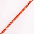 Vista macro de cuentas bañadas en oro y cilindros de piedra naranja en un collar elegante - Rojo