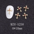 Macro detail of a 8x10mm gold cross nail charm with pink rhinestone for DIY art - Gold Cross with Pink Stone (A258)