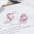 Macro view of pink heart-shaped cubic zirconia stud earrings with silver three-prong setting - Pink Zirconia