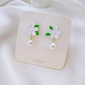 Close-up of tulip flower earrings with green leaves, white pearls, and 925 silver needles - White Gardenia Stud Earrings