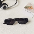 Fashionable black oval sunglasses with star detail and dark lenses in a flat lay setup - Black