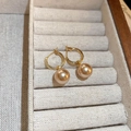 Gros plan de créoles dorées avec perles champagne dans un coffret à bijoux chic - 61# Créole - Perle Cercle Champagne