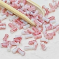 Détail macro de perles en céramique cylindriques avec veinures de marbre rouge - Style Bambou (J162#)
