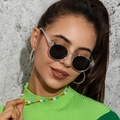 Vintage retro sunglasses with transparent resin frames and dark lenses on a smiling model - Clear