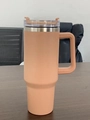 Pink 40oz stainless steel insulated tumbler with handle and clear straw lid on desk - Khaki