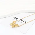 Detalle de collar de mariposa con circón amarillo y cadena de acero de titanio dorado - Amarillo