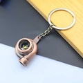 Detailed macro view of a metallic copper turbocharger keychain with silver ring - Turbocharger / Red Bronze