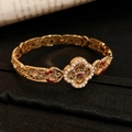 Detailed macro view of gold hollowed bracelet featuring pearl inlay and ruby gemstone - Vintage Hollow Ruby Style
