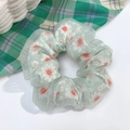 Close-up of green daisy pattern scrunchie with transparent mesh layer on white surface - Green Sunflower Lace Double Layer