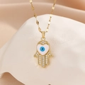 Macro detail of Hamsa Hand pendant with heart-shaped Evil Eye and sparkling zircon stones - Gold White Zircon White Oil