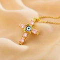 Goldene Kreuzkette mit rosa Steinen und blauem Evil-Eye-Detail auf Seide - Rosa