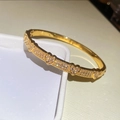 Vista macro di un bracciale dorato a cuore con zirconi incastonati su scatola bianca - Stile Pavé a Cuore / Oro - Cuore