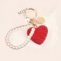 Dettaglio portachiavi a cuore con strass rossi, cinturino di perle e finiture dorate - Rosso con cinturino di perle