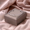 Minimalist silver knot open bangle featuring hollow oval design on satin background - Silver Geometric Circle Style