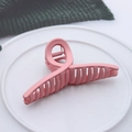 Pink matte finish cross claw clip for women on a white textured ceramic display plate - Matte Cross Pink
