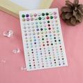 Colorful round adhesive face jewels in various sizes and shades on a pink fabric - Mixed Color Round Rhinestones