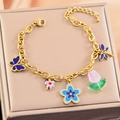 Golden bracelet with colorful blue butterfly, floral, and heart-shaped enamel charms - Bracelet