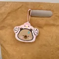 Cute Capybara plush keychain wearing pink chicken outfit hanging on a brown handbag - Pink Chicken Capybara Style