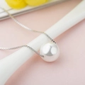 Macro shot of a minimalist white pearl pendant necklace with a silver box chain finish - Minimalist Single Pearl Necklace