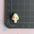 Macro view of 1.5cm resin donut accessory with paw print detail on ruler grid - Green Ball Popsicle