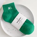 Vibrant green cotton socks with white NA embroidery and premium paper packaging wrap - One Size / Velvet Green