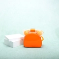 Close-up of a creative orange telephone shaped handbag with glossy patent leather finish - Orange