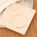 Detailansicht eines handgefertigten Boho-Natursteinarmbands mit Goldperlen auf Steingrund - Gebrochenes Weiß