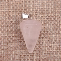 Macro shot of faceted pink crystal dowsing pendulum pendant on a woven burlap texture - Rose Quartz
