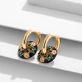 Macro detail of vintage floral enamel earrings with pink flowers and gold hoops on a white stand - Black Background Pink Scroll Flower