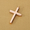 Detailed view of a polished rose gold stainless steel cross pendant on textured paper - Rose Gold (KP97232-KFC) / Pendant Only