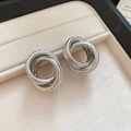 Macro shot of silver interlocking triple ring stud earrings with stardust frosted finish - Silver Needle - Silver Frosted Interlocking Rings