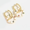Detail van gouden oorringen met wit emaille ring en meerkleurige edelstenen op wit decor - Witte Ring