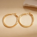 Dettaglio di orecchini a cerchio a doppio strato placcati in oro 18k su sfondo beige - Cerchio-Oro (Placcato Oro 18K)