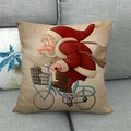 Housse de coussin de Noël avec Père Noël à vélo bleu sur tissu en lin beige - Père Noël Roulant à Bicyclette Bleue