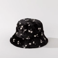 Close-up of fluffy faux fur bucket hat with white cherry pattern on black fabric - M (56-58cm) / Black
