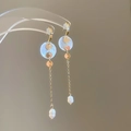 Detail van elegante gouden hangoorbellen met ronde schelpen, kettingen en witte parels - 41# Zilveren oorknopje - Goud Wit Parel Schelp Lange Stijl