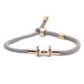 Macro detail of a grey adjustable rope bracelet with a gold devil eye enamel bead - Grey Rope With Evil Eye