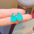 Pear cut Paraiba blue stone stud earrings in silver prong setting held for size reference - Earrings Pair / Paraiba Blue