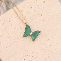 Collier papillon doré avec ailes vertes translucides et zircons sur support en pierre beige - Vert paon