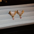 Macro shot of vintage triangle zircon earrings with gold plating on gray velvet box - White Zirconia Triangle Style